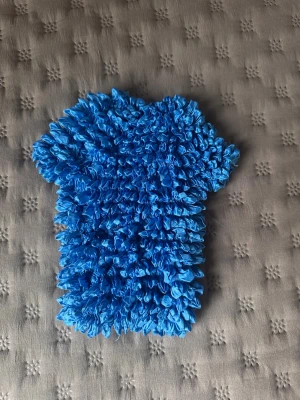 Blå smockad topp i syntet - Blå topp som krymper ihop men är otroligt stretchig, passar alla storlekar upp till S/M. Modellen är kortärmad och croppad, vilket ger en cool och trendig vibe. Materialet känns som syntet och färgen är riktigt klarblå. Perfekt för dig som vill sticka ut med din outfit.