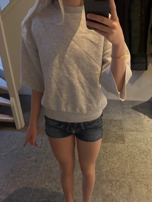 Grå kortärmad tjock tröja från Gina Tricot XS - Säljer en ljusgrå kortärmad hoodie från Gina Tricot, basically basics-kollektionen. Tröjan har en klassisk rund halsringning, breda ärmar. Perfekt för en avslappnad och stilren look. Materialet är mjukt och bekvämt.