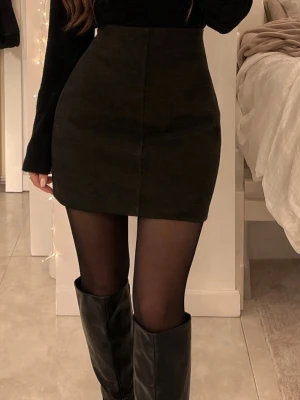 Svart kortkjol  - En stilren svart kortkjol med rak passform. Kjolen är enkel och klassisk utan mönster eller detaljer, vilket gör den lätt att matcha. Tillverkad i mjukt bomullsmaterial som känns bekvämt mot huden. Perfekt för dig som gillar minimalistisk stil.