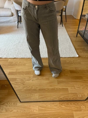 Grå raka jeans från NA-KD - Säljer ett par grå jeans från NA-KD i rak modell med klassisk femficksdesign. Jeansen har en avslappnad passform och är tillverkade i denim. Perfekta för en cool och avslappnad stil. Uppsydda och lite slitage längst ner.