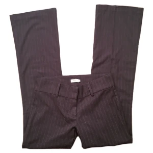 Randiga/ kritstrecksrandiga Lowwaist bootcut/ flare kostymbyxor, Nelly, y2k/ cyber/ alt/ 2000s/ 2000tal/ 00s/ 00tal/ 60s/ 60tal/ 70s/ 70tal - Bruna lågmidjade utsvängda kritstrecksrandiga kostymbyxor! Midjemått 83cm Grenhöjd 20,5cm Innerbenslängd 80,5cm Benvidd (längst ner) 25,5cm rakt över 