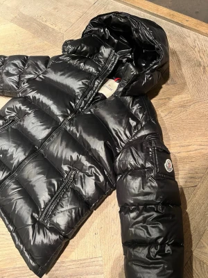 Moncler jacka, Maya - Säljer nu min älskade moncler jacka då jag har köpt en ny, den är i jättebra skick och inga skador. Äkta dock utan kvitto men äktighetsbevis i jackan. Den är endast  använd 3 månader denna vinter. Stl 160, eller motsvarar XS. Jag är en XS/S💕. Är varm!🥰priset går att diskuteras vid snabb affär.