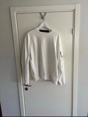Vit sweatshirt från Cp Company - Vit sweatshirt från Cp Company. Knappt använd. Mycket bra skick. Storlek Xl men sitter som L.
