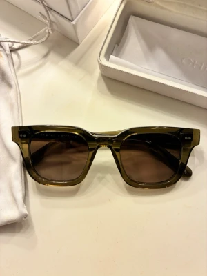  Chimi solglasögon 04 chimi  - Säljer en elegant solglasögon Chimimed klassisk design. Väskan har en stilren form. Perfekt för dig som vill ha en lyxig accessoar med ikonisk känsla. Chimi-loggan syns på insidan av väskan. 04 grön 