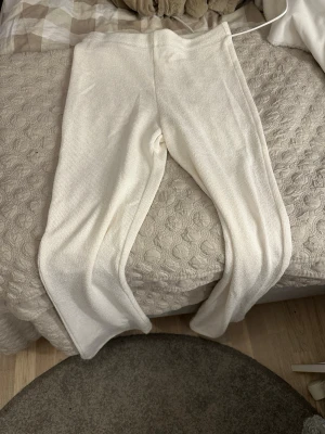 Vita ribbade leggings - Säljer ett par vita ribbade leggings med hög midja och stretchigt material. De har en mjuk och bekväm passform, perfekta för en avslappnad stil. Inga synliga loggor eller märken. Passar dig som gillar basic och stilrent. Lite synliga igenom. Perfekta strandbyxor. Köpare står för frakt 😊