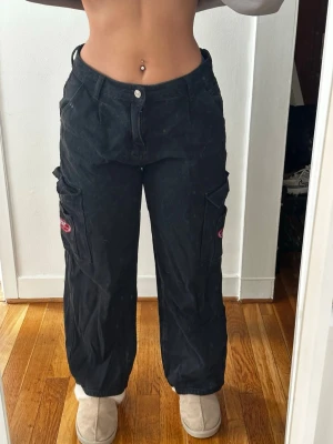 Svarta cargobyxor från SRAW - Coola svarta cargobyxor från SRAW med bred passform och stora fickor på sidorna. 