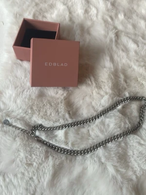 Kedjehalsband i silver från Edblad - Snyggt och stilrent halsband från Edblad i blankt silverfärgat metallmaterial. Halsbandet har en chunky kedjedesign som ger en modern och trendig look. Perfekt accessoar för att lyfta vilken outfit som helst. 