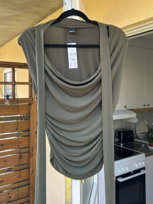 Olivgrön omlott topp från Gina Tricot - Snygg olivgrön omlott topp från Gina Tricot med draperad framsida och långa knytband.💚nypris 299