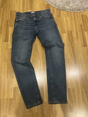 Blå raka jeans från Cubus - Snygga blå jeans från C i rak modell med klassisk femficksdesign. Jeansen har gul kontrastsöm och normalhög midja. Perfekta för dig som gillar en tidlös och avslappnad stil. Materialet är klassisk denim i bomull.
