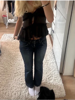 Mörkblå bootcut jeans med låg midja från Lee!! - Säljer ett par super snygga mörkblå bootcut jeans med låg midja och klassiska fem fickor. Jeansen har snygga kontrastsömmar och lätt slitning på låren för en cool look. Perfekta till vardags och passar till det mesta. Materialet känns som bomullsdenim. Köpta här på Plick för 600kr (lånade bilder från förra annonsen). Använd fåtal gånger, nästan som nya. Waist: 26 längd: 34. Hör av er vid frågor!❣️