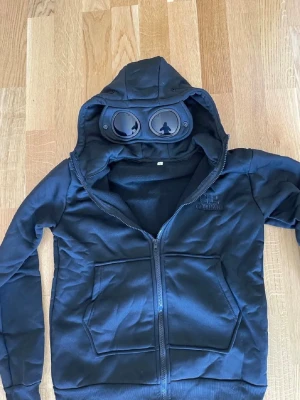 Svart hoodie från C.P. Company - Denna tröja är storlek Medium men sitter som xs/s. Säljer tröjan då den är för liten. Testat den en gång inte mer använd än det
