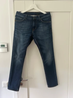 Mörkblå jeans Evolve 30/30 - Snygga mörkblå jeans från Evolve i klassisk femficksmodell med kontrastsömmar och läderpatch bak. Jeansen  är tillverkade i slitstarkt bomullsmaterial. Perfekt för dig som gillar stilrena och tidlösa jeans. Kontakta vid eventuella frågor!😁