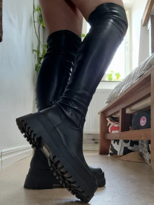 Over knee boots with platform - Gorgeous platform over knee boots. Stretchy faux leather that fits both people with both narrow and bigger calves. Very sparingly used, just an almost invisible scratch on one of the boots (see picture). Soft and perfect for a whole night of dancing or for a festival. It says they are size 37, but I would say closer to 38 (meassured 24.5 cm long inside of the sole w/ tape measure and I myself have exactly 24.5 cm long feet and they fit just snugg :)). New price 999 sek