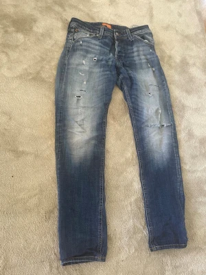Jack & Jones  - Säljer dessa tvär feta Jack & Jones jeans med slitningar modell slim Glenn storlek 31/32 passar bra på mig som är 180 skicket är 8/10