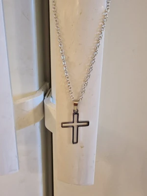 Halsband hålkorsberlock - Minimalistiska hålkorsberlockshalsband ink kedja. Rostfritt stål. Kedja 50 cm. Berlock 3,3 cm hög. Bredd 2,3 cm. Silverfärg.