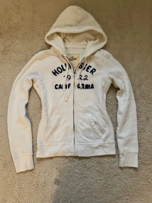 Zip up Hoodie Hollister  - Vit zip up Hoodie ifrån Hollister, har lite skavanker se bilder! 