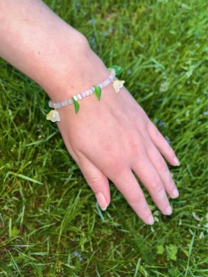 Armband med blommor  - Superfint armband med pastell-glaspärlor och hängande blommor o blad. Passar handled XS-S.         Köp två armband för 60kr ✨