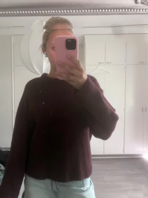 Vinröd stickad tröja - Mysig vinröd stickad tröja med avslappnad passform och rund halsringning. Tröjan har långa ärmar och är tillverkad i ett mjukt material som passar perfekt för kyligare dagar. Enkel och stilren design utan synliga loggor eller mönster.