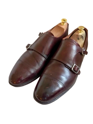 Snygga monkstrap Meermin (44) - Snygga bruna monks/loafers ifrån Meermin. Detta är en klassisk monkstrap-modell med dubbla spännen i silverfärg. Skorna har rundad tå och är tillverkade i slätt läder som ger en stilren look. Perfekta för dig som vill ha en dressad men avslappnad stil. I mycket bra begagnat skick. 