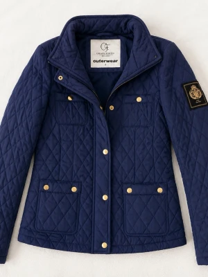 Marinblå quiltad jacka från chiara forthi  - Stilren marinblå quiltad jacka från chiara forthi med guldfärgade knappar och dragkedja. Jackan har fyra fickor framtill och ett emblem på ena ärmen. Perfekt för dig som gillar klassisk och tidlös design.