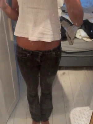 Svarta slim fit jeans med låg midja - Säljer ett par svarta slim fit jeans med låg midja och klassisk femficksdesign. Jeansen har smal passform och raka ben, perfekta till en avslappnad stil. Materialet är troligtvis bomull med stretch för extra komfort. Avklippta samt slitning (se sista bilderna)💕
