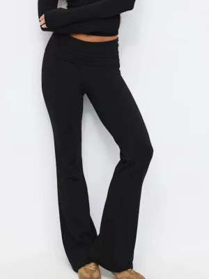 Svarta bootcut leggings med lågmidja - Säljer ett par svarta leggings med bootcut-modell och låg, vikbar midja. De är tillverkade i ett stretchigt och mjukt material som sitter skönt på kroppen. Perfekta för dig som gillar en avslappnad men trendig look.