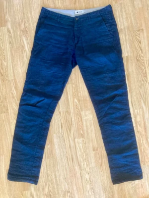Mörkblåa linnebyxor  - Prisvärda linnebyxor från NN07 NO Nationality. Byxorna är i gott skick och har enbart små tecken på användning.   Specifikationer  Waist: 32. Length: 34. Material: 100% linen.   Spana in mina övriga annonser för snygga prisvärda plagg ⭐️.