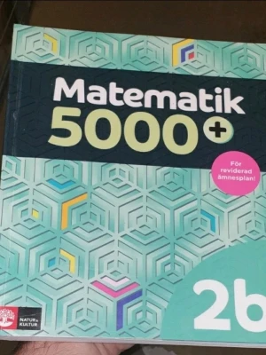 Matematik 5000+ 2b - Matematik 5000+ 2b är en kursbok i matematik för gymnasiet. Omslaget är turkost med geometriskt mönster i blått, gult och rosa. Boken är tryckt i mjukt papper och har tydliga rubriker. Passar dig som läser matematik på gymnasienivå.