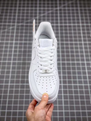 Nike Air Force 1 vita sneakers - Klassiska Nike Air Force 1 sneakers i helvitt läder med vit sula och vita skosnören. Skon har perforerade detaljer på tån för ventilation och den ikoniska swoosh-loggan på sidan. Perfekt för dig som gillar en clean och tidlös stil. Finns i alla storlekar från 35-46