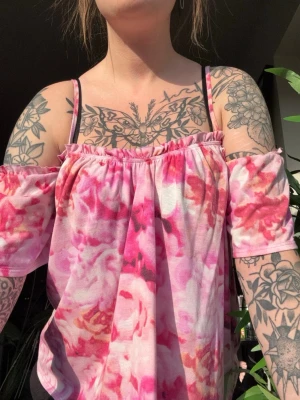 Blommig offshoulder topp rosa/vit - Säljer en söt offshoulder topp med blommigt mönster i rosa och vitt. Toppen har tunna axelband och korta ärmar som sitter nedanför axlarna. Materialet känns mjukt och luftigt, perfekt för varma dagar. xS med bra stretch i så kan nog passa för M 