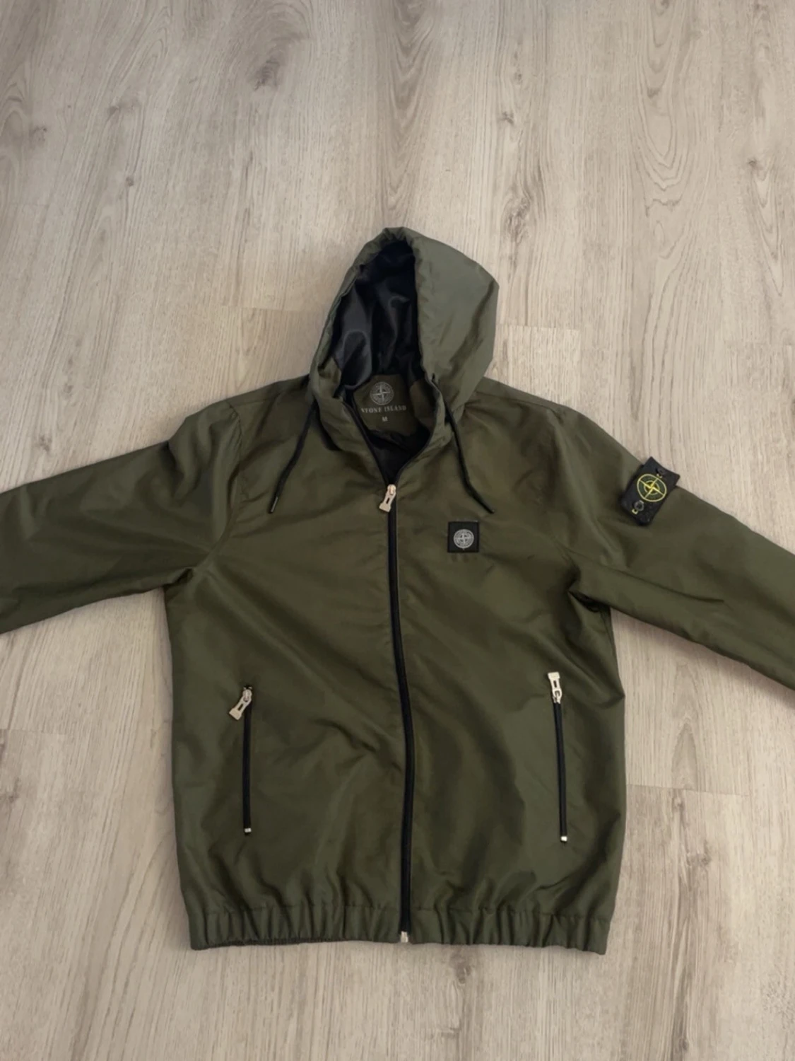 Grön vindjacka med huva Stone Island