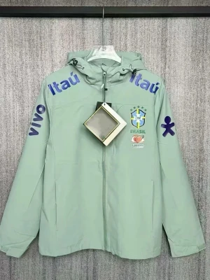 Ljusgrön Brasilien vindjacka med huva - Snygg ljusgrön vindjacka från Nike med Brasilien-logga. Jackan har huva, hel dragkedja och tryck i blått på ärmar och axlar. Perfekt för dig som gillar fotboll och streetwear. Storleken på jackan är xl men den är liten i storlek vilket gör att den passar i storlek Xs/s. Aldrig använt den. Helt nytt skick!!! 