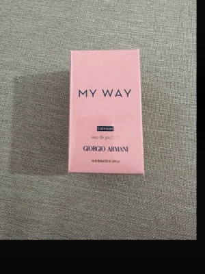 My Way Intense parfym Giorgio Armani 90 ml - My Way Intense eau de parfum från Giorgio Armani i en elegant rosa förpackning. Parfymen har en modern och stilren design med tydlig logotyp och text i mörkblått och guld. Perfekt för dig som gillar exklusiva dofter.