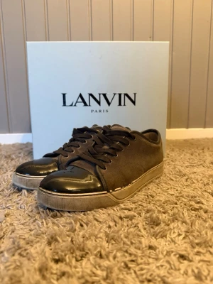 Grå Lanvin sneakers med lackad tå - Tja säljer ett par grå lanvin med lackad tå bra skick endast några få defekter ny pris ligger på eu t 4-5000 kr o jag säljer dessa för 999 men pris kan absolut! Diskuteras.  / storlek 41 men stor i storlek så passar bäst 42