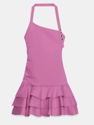 Rosa kort klänning med volanger - Säljer en oanvänd rosa kort klänning med asymmetrisk halsringning och knappar på axelbandet. Klänningen har volangdetaljer nertill och är ärmlös med halterneck. Perfekt för dig som vill sticka ut med en färgstark look.