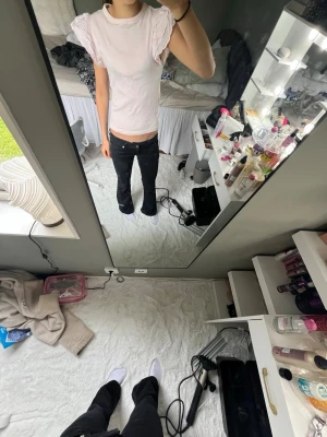 Ljusrosa topp med volangärmar - Supersöt ljusrosa topp med volangdetaljer på axlarna och rund hals. Toppen är ribbad och har en tight passform samt är kortärmad. Perfekt för dig som vill ha söt topp till sommaren