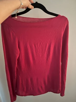 Mörkröd långärmad topp - En enkel och stilren mörkröd långärmad topp med rund halsringning. Tunn och mjuk i materialet, perfekt att matcha med jeans eller kjol. Inga synliga detaljer eller tryck, bara en clean look.