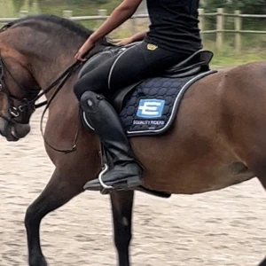 Marinblå schabrak Equaline - Säljer ett marinblått schabrak från Equaline med vit kant och stor blå logga på sidan. Shabraket är o storlek full, Snygg detalj till din hästutrustning. Pris diskuteras 