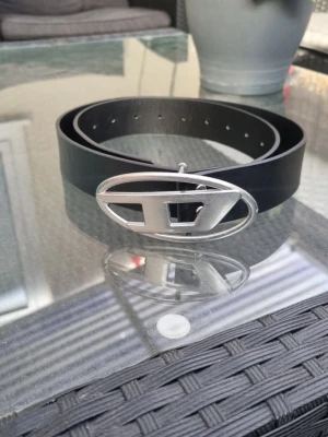 Svart Diesel bälte NY! - Snyggt och nytt Diesel bälte. Aldrig använt. Skick på bilden. 3,5 cm bred och 110 cm lång.