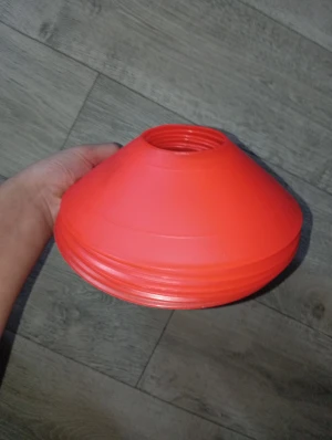 Röda markeringskoner för träning - Säljer ett set med sex röda markeringskoner i plast, perfekta för fotbollsträning, agility eller andra sportaktiviteter. Konerna är lätta, stapelbara och har en klassisk rund form med hål i toppen. Smidiga att ta med till planen eller gymmet.