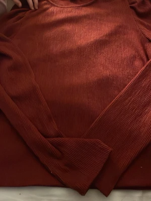 Roströd ribbad stickad tröja - Säljer en roströd ribbad stickad tröja från Stradivarius. Tröjan har rund halsringning, långa ärmar och är gjord i ett mjukt, stretchigt material. Perfekt för lager på lager och ger en snygg, avslappnad look.