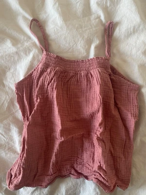 Rosa linnetopp från ONLY - Säljer en söt rosa linnetopp från ONLY med tunna axelband och smockad överdel. Perfekt nu inför sommaren 💞Står storlek M men den är mindre egentligen. Passar storlek XXS och XS. 