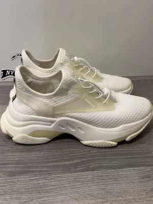 Vita sneakers från Steve Madden - Säljer dessa fina Steve Madden skor då dom inte går till användning. Stilrena vita sneakers från Steve Madden med chunky sula och meshmaterial för extra andningsförmåga. Skorna har vita snören med snabblås och detaljer i transparent plast samt svartvit logotyp på hälen. Perfekta för en trendig och sportig look. Enbart använda 2 gånger.