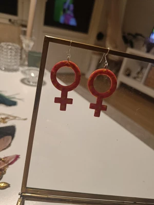 Rosa och gula feministörhängen - Unika örhängen i form av kvinnosymbolen, handgjorda i rosa och gult mönstrad polymerlera. De har krokar i metall och en cool, statement-look som verkligen sticker ut. Perfekta för dig som vill visa din stil och stå för något viktigt. Strass!
