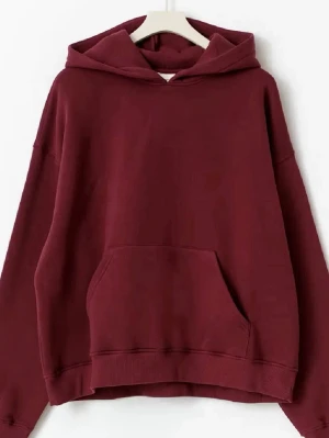 Vinröd hoodie Gina tricot  - En stilren vinröd hoodie med huva och stor magficka. Modellen är oversized med ribbade muddar vid ärmslut och nederkant. Perfekt för en avslappnad look. Materialet är mjukt skönt. Inga defekter eller nopprig.