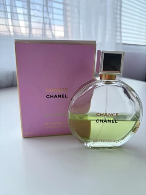 Chanel Chance Eau Fraîche parfym 100 ml - Chanel Chance Eau Fraîche är en elegant parfym i en rund glasflaska med gulgrön vätska och silverfärgad fyrkantig kork. Förpackningen är ljuslila med gulddetaljer och klassisk Chanel-logga. Flaskan rymmer 100 ml och utstrålar lyxig och modern känsla. SE FLASKA FÖR RESTERANDE INNEHÅLL