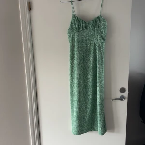 Grön långklänning med smala axelband - Snygg grön långklänning med smala axelband och slit.  Perfekt för sommarens alla tillfällen.