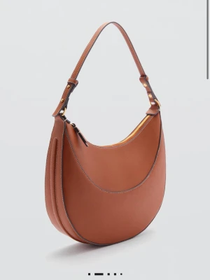 Väska från mango (slutsåld) - Snygg brun handväska med justerbart axelband och guldfärgade detaljer. Väskan är tillverkad i läderimmitation och har dragkedja upptill.