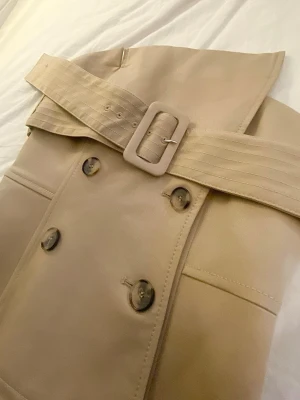 Trench-korsett från Zara - Beige korsett/tubtopp i trenchcoatstil från Zara. Aldrig använd, storlek xs men skulle säga närmre xxs🤎