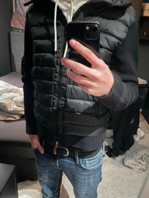 Svart cardigan från Moncler - Riktigt fräsch moncler cardigan nu till våren. Jackan är riktigt stil ren och har den svarta batchen istället för den orginala. Den är lite liten i storlek, jag är 1,85 på bilden och den är för kort. Den sitter som en xs skulle jag säga. Det negativa med jackan är vid knappen till ena fickan har knappen låstnat så fickan går ej att stänga. Tar emot byten också.